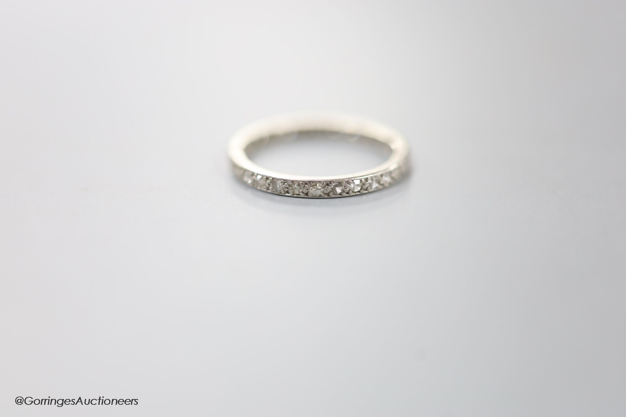 A white metal and diamond chip set full eternity ring, size L, gross 2.2 grams.